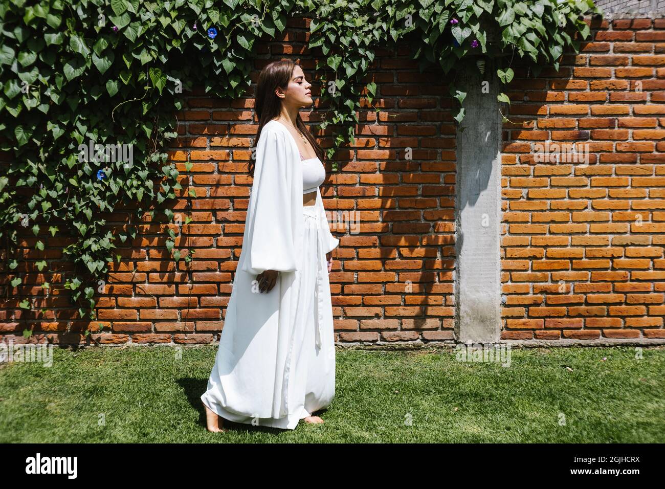 Junge mexikanische Frau mit geschlossenen Augen meditiert im Garten in einer ganzheitlichen Therapie in Lateinamerika Stockfoto