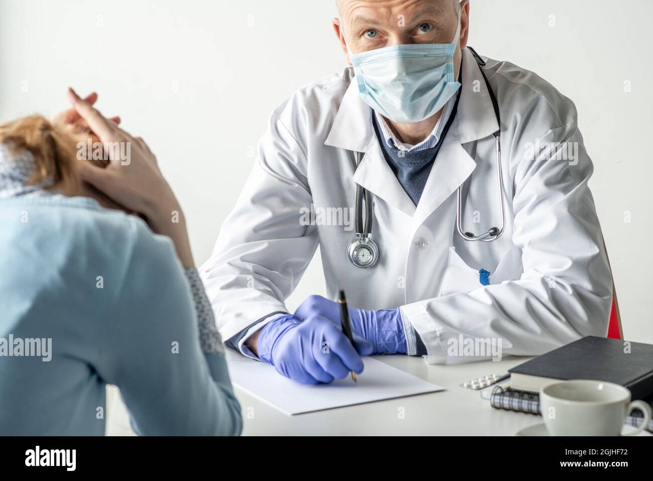 Covid-19, Prävention von Viren, medizinisches Personal und Impfkonzept. Seriös zuversichtlich männlichen Arzt in weißem Mantel und medizinische Maske, trägt eine Brille, Stockfoto