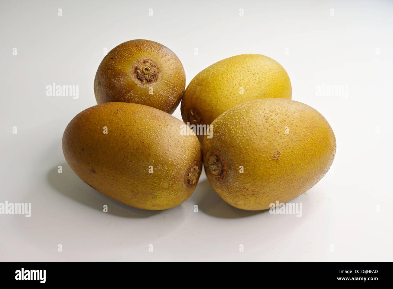 Bund von ganzen goldenen Kiwifruitbeeren (Actinidia chinensis) auf weißem Hintergrund Stockfoto