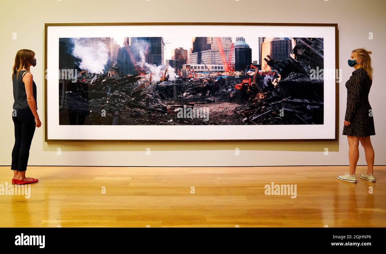 Mitarbeiter des Museums betrachten Arbeiten, die Teil der Ausstellung „Wim Wenders: Photographing Ground Zero“ im Imperial war Museum in London sind. Bilddatum: Freitag, 10. September 2021. Stockfoto