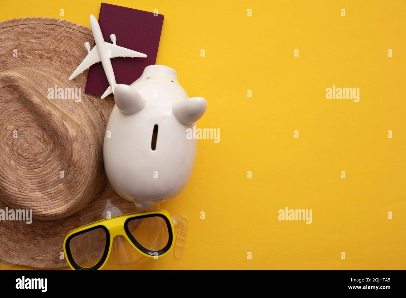 Sparen für einen Sommerurlaub. Sparschwein mit Urlaubsreisen-Accessoires Stockfoto
