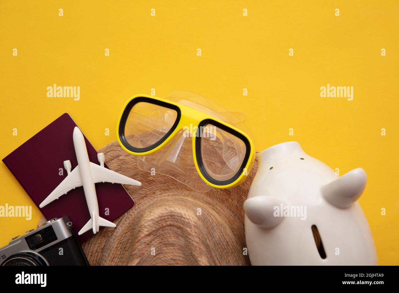 Sparen für einen Sommerurlaub. Sparschwein mit Urlaubsreisen-Accessoires Stockfoto