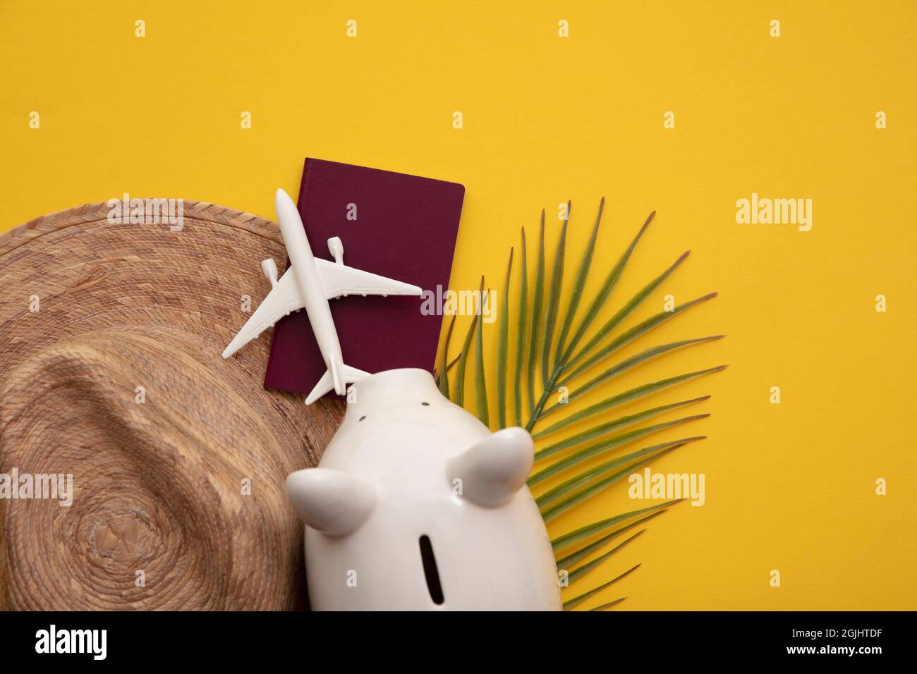 Sparen für einen Sommerurlaub. Sparschwein mit Urlaubsreisen-Accessoires Stockfoto