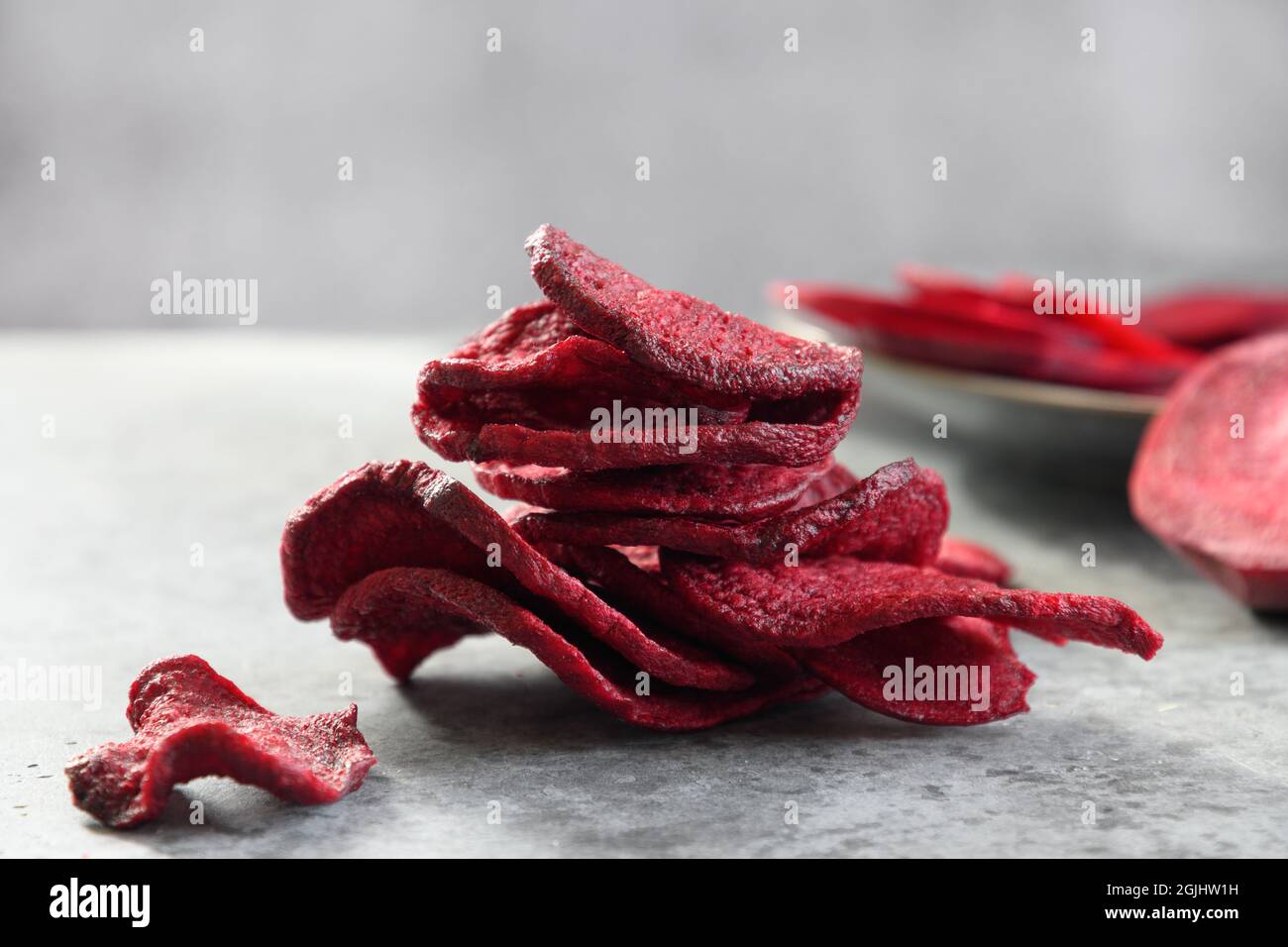 Pflanzliche Rote Beete-Chips auf grauem Hintergrund. Veganer Snack. Nahaufnahme. Stockfoto