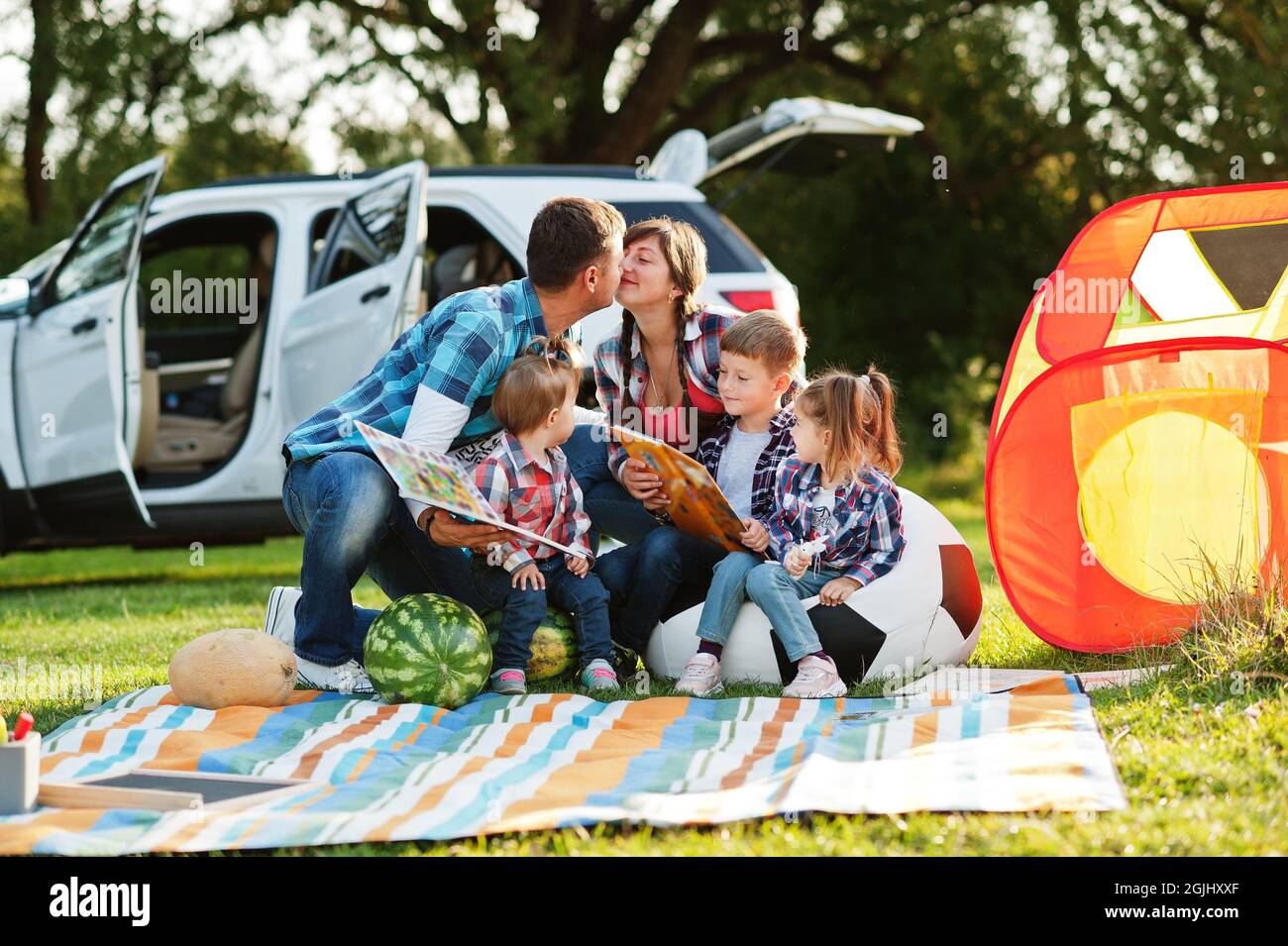 Familie verbringt Zeit zusammen. Drei Kinder. Picknickdecke im Freien.  Vater küsst Mutter Stockfotografie - Alamy