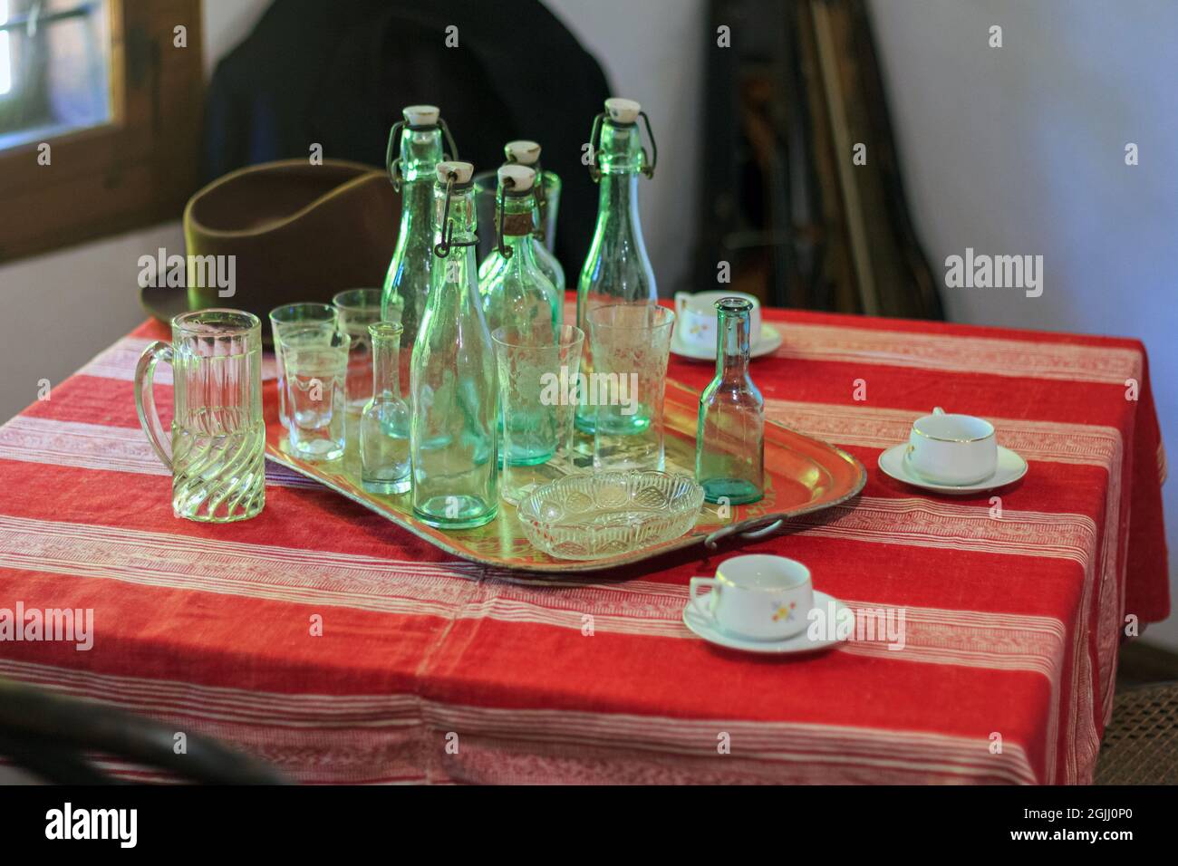 Vintage grüne Flaschen und Glasbecher auf dem Tisch im alten Barinterieur Stockfoto