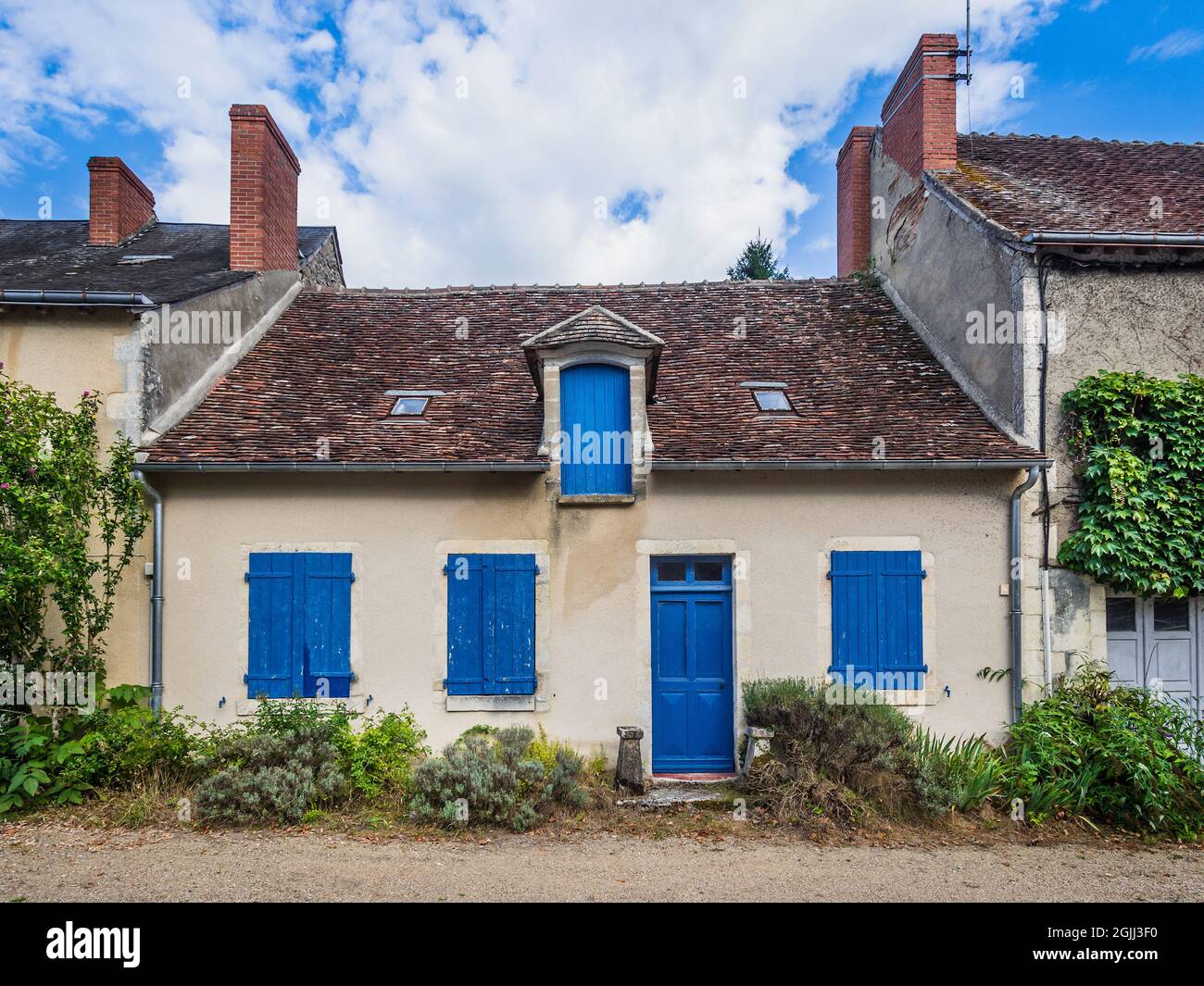 Kleines Reihenhaus mit blauen Fensterläden - Ciron, Indre (36), Frankreich. Stockfoto