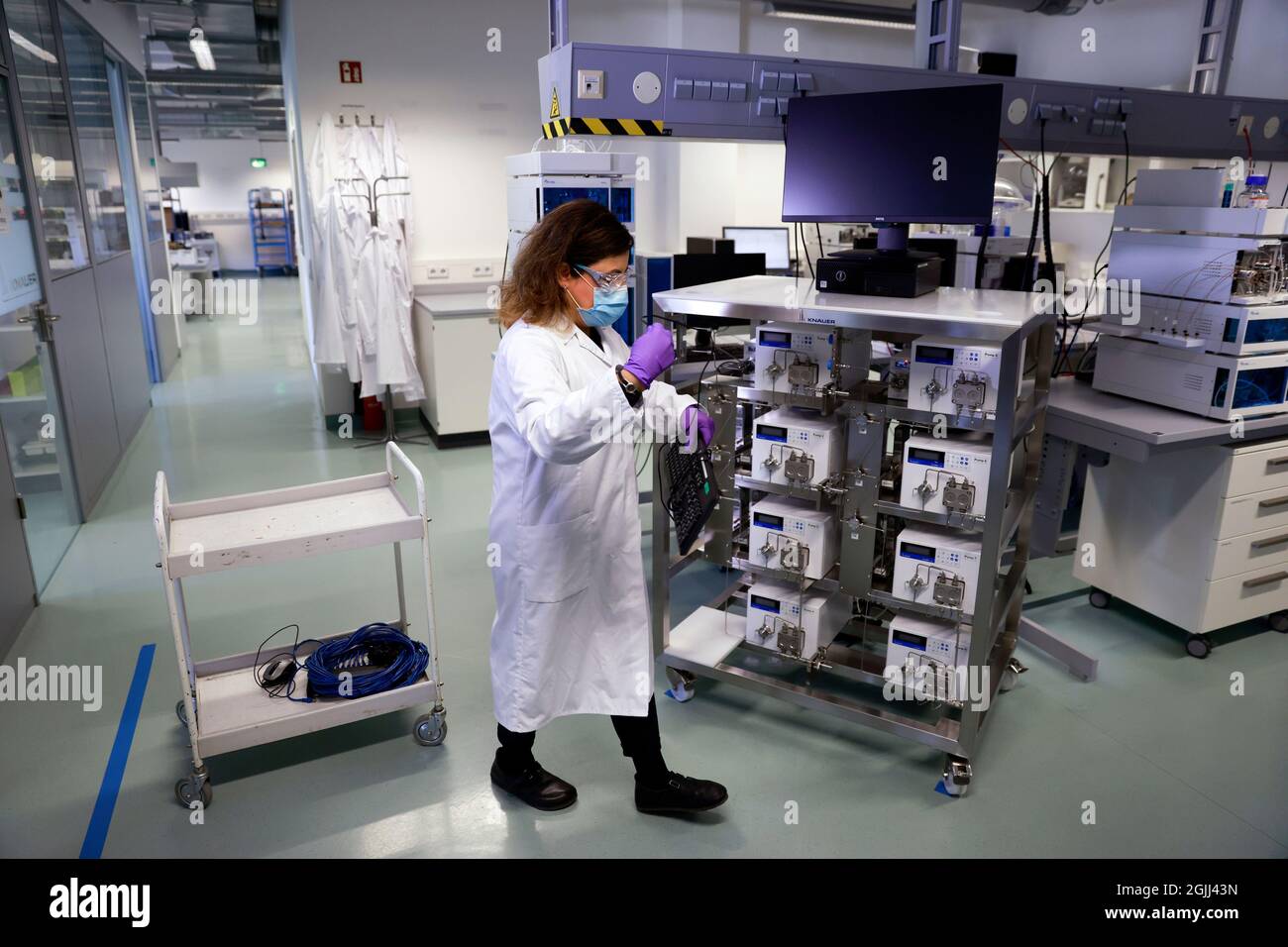 Berlin, Deutschland. September 2021. Bei der Knauer Wissenschaftliche Geräte GmbH steht während des Besuchs von Bundeskanzlerin Merkel ein Mitarbeiter neben "Customized Impingement Jets Mixing Skid for large scale production of Lipid nanoparticles". Kredit: Odd Andersen/AFP Pool/dpa/Alamy Live Nachrichten Stockfoto