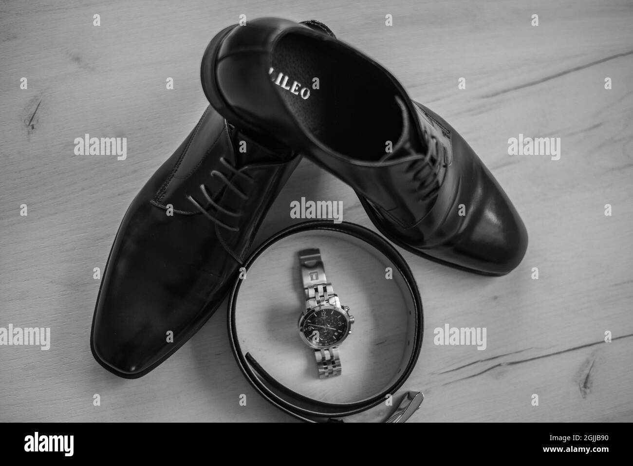 KAKANJ, BOSNIEN UND HERZEGOWINA - 22. Aug 2021: Eine Nahaufnahme von schwarzen männlichen Schuhen und einer Uhr in einer Schachtel an einem Hochzeitstag Stockfoto