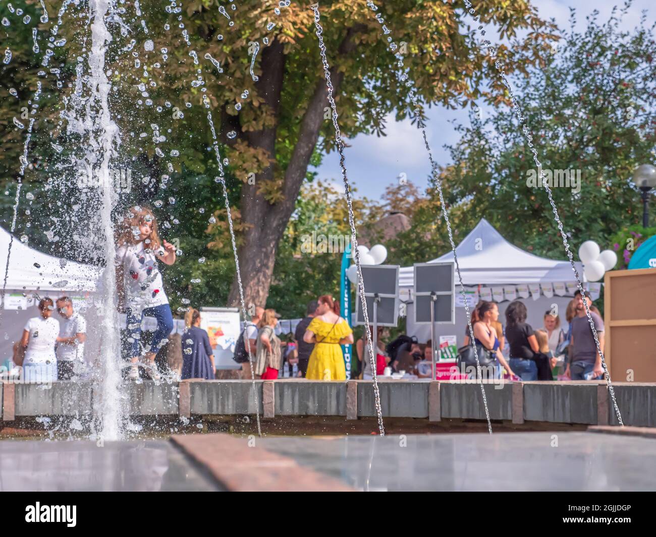 Menschen, die im Herbstpark in Kiew (Kiew) in der Ukraine am Brunnen spazieren, reden und sich ausruhen. Urbane Lebensart. Stockfoto