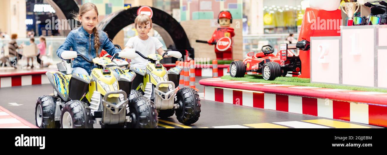 Moskau, Russland, 28. Mai 2021 kleine Kinder Junge und Mädchen Spaß Reiten einer kleinen Elektroautos auf Sportplatz in einem Spielplatz für Unterhaltungen. Kinder ri Stockfoto