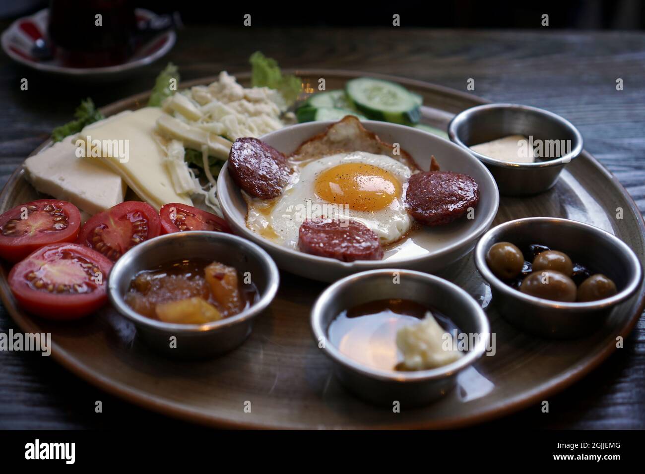 Das türkische Frühstück war schon fertig. Es gibt Eier mit Wurst, Tomaten und Gurken in Scheiben, Honig, Marmelade, Oliven am Tisch. Stockfoto