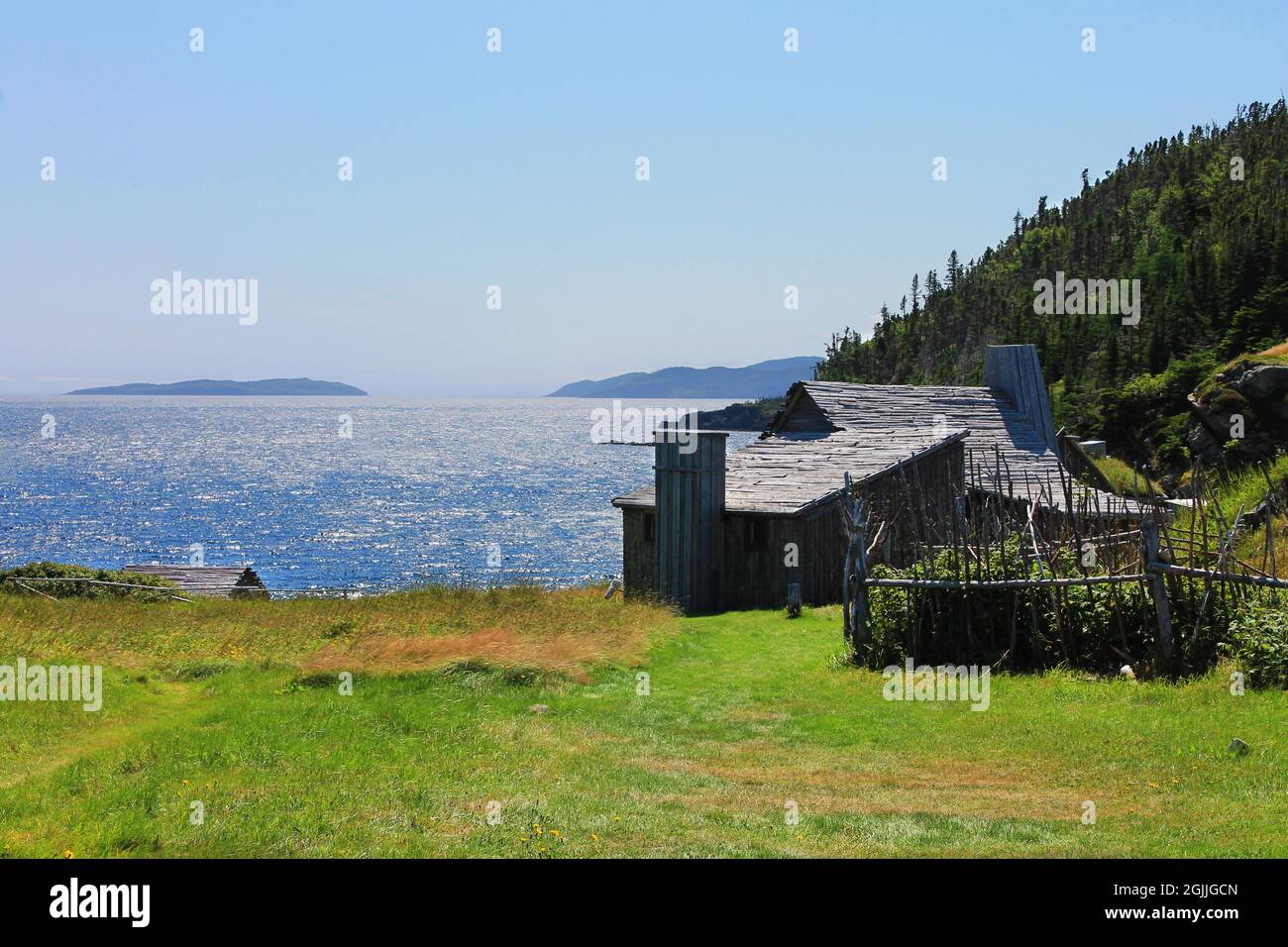 Ein altes Blockhaus auf einem Hügel mit Blick auf den Ozean, Random Passage Site, New Bonaventure, Neufundland. Stockfoto