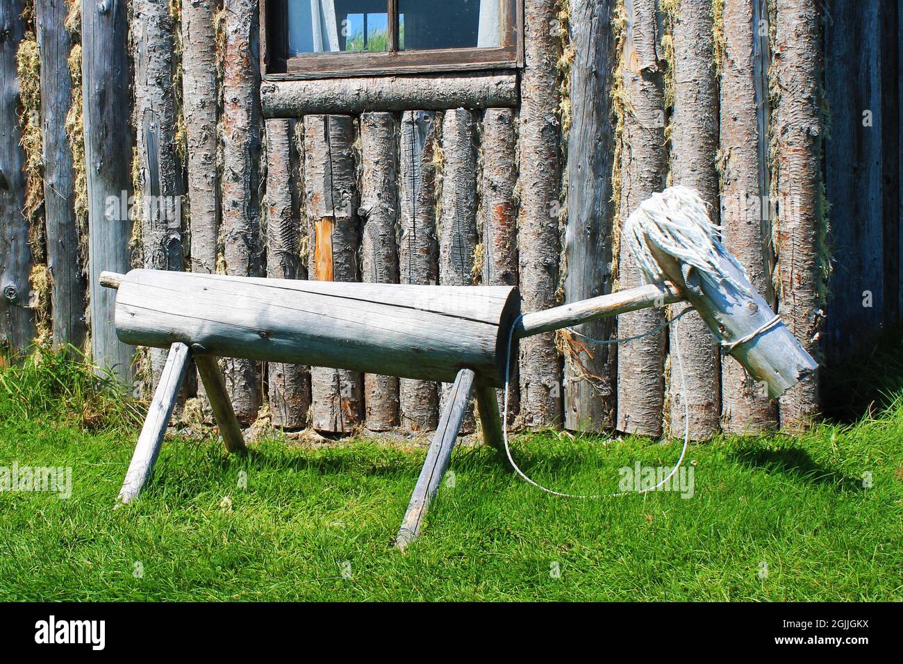 Ein altmodisches Hobby-Pferdespielzeug aus Holz, hergestellt aus Baumstämmen, an der Seite einer Blockhütte, Random Passage Site, New Bonaventure, NL. Stockfoto