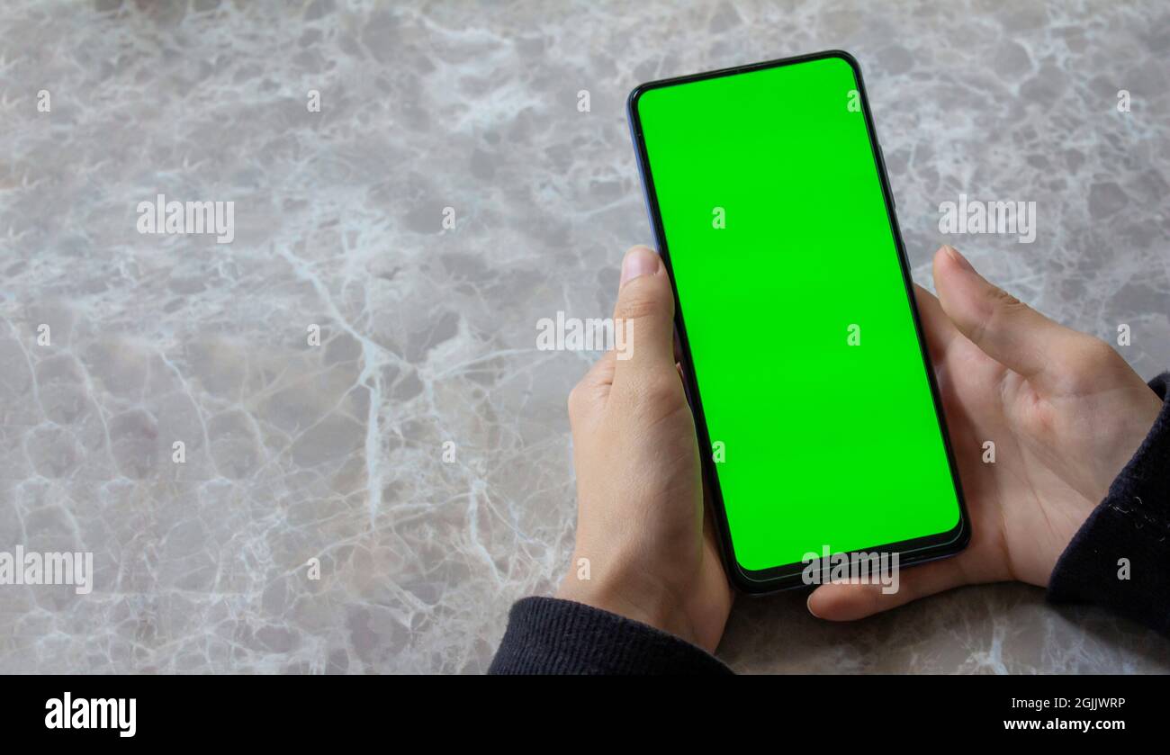 Mockup Bild der Frau mit grünen Bildschirm Handy auf Marmor-Tisch Hintergrund. Draufsicht, Kopierbereich. Stockfoto