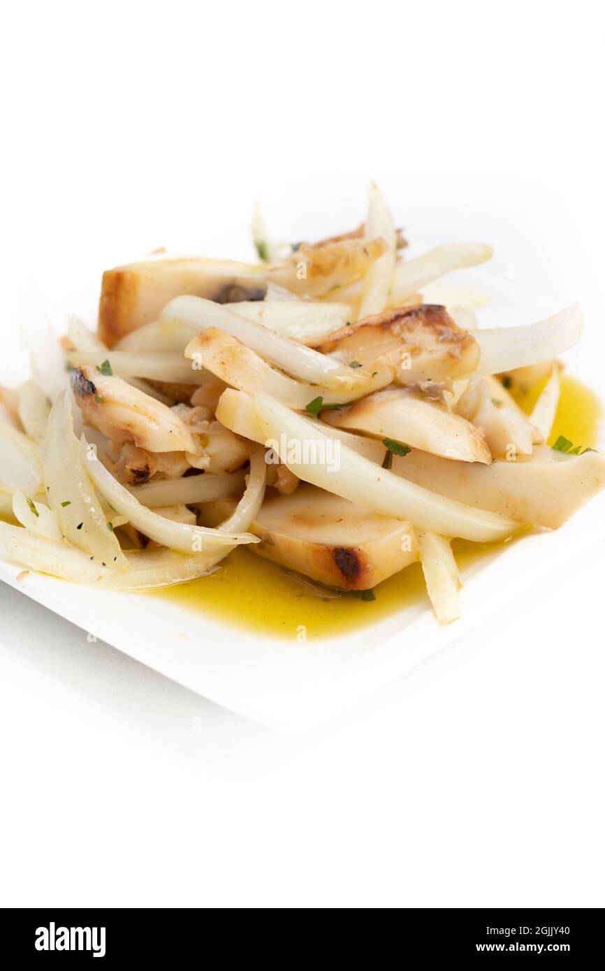 'Chocos aliñado', ein typisch spanisches Essen, Tintenfisch in Streifen mit Zwiebeln. Platte auf Weiß isoliert Stockfoto