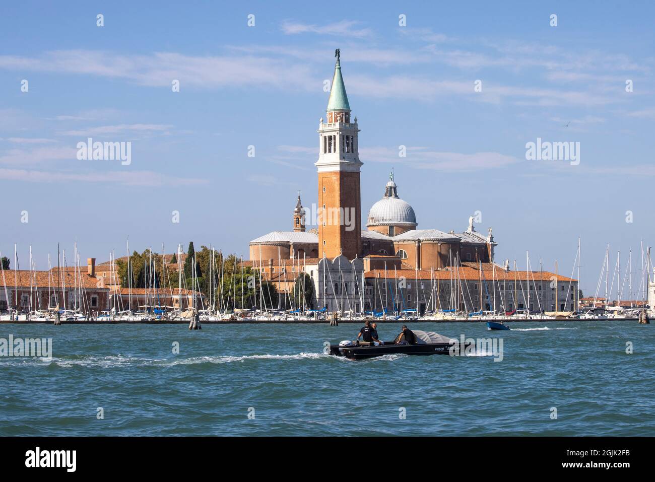 Ein Boot fährt an der Insel San Giorgio Maggiore vorbei, die sich gegenüber dem Markusplatz in Venedig befindet und östlich der Giudecca liegt und von Monet gemalt wurde. Stockfoto