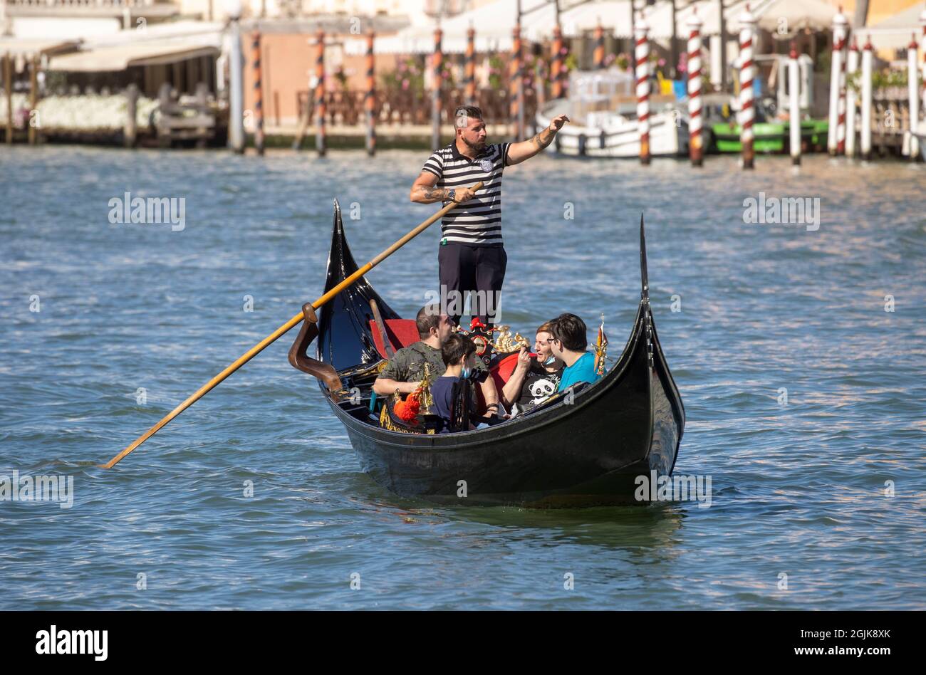 Eine Gondel auf dem Canal Grande in Venedig, die bei San Marco in die Lagune führt. Touristen genießen die wunderschöne Architektur Venedigs von einer Gondel aus. Stockfoto