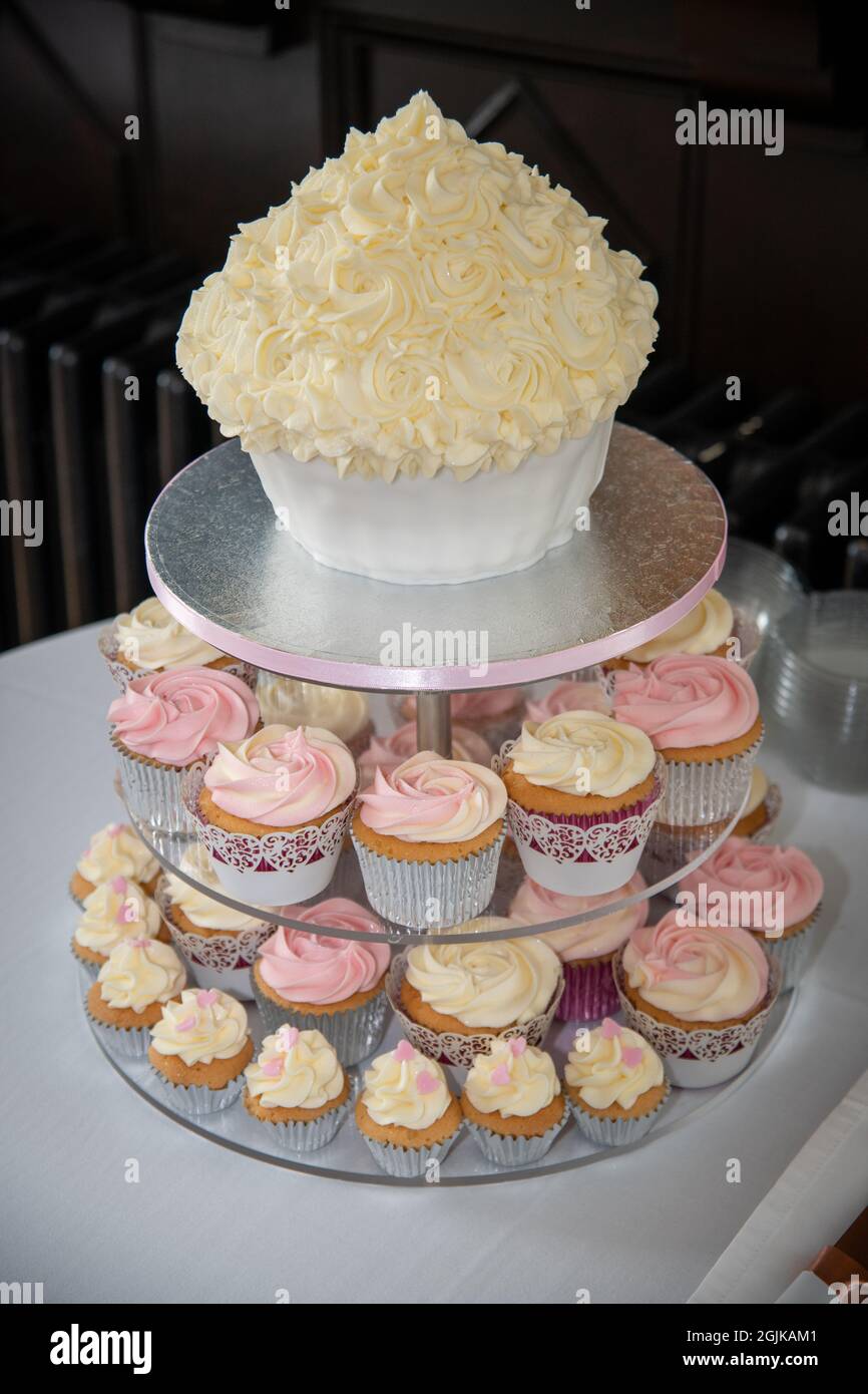Cupcakes auf einem Stand in Form eines großen Kuchens für einen Hochzeitsempfang Stockfoto