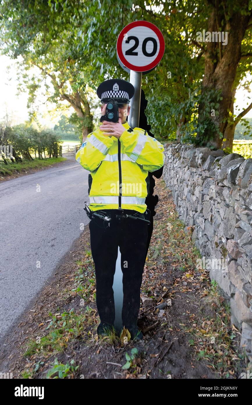 Karton-Ausschnitt gefälschte Verkehrspolizist mit Geschwindigkeitskanone auf 20mph Geschwindigkeitsbegrenzungsschild angebracht, Fortinghall, Perth und Kinross, Schottland, Großbritannien Stockfoto