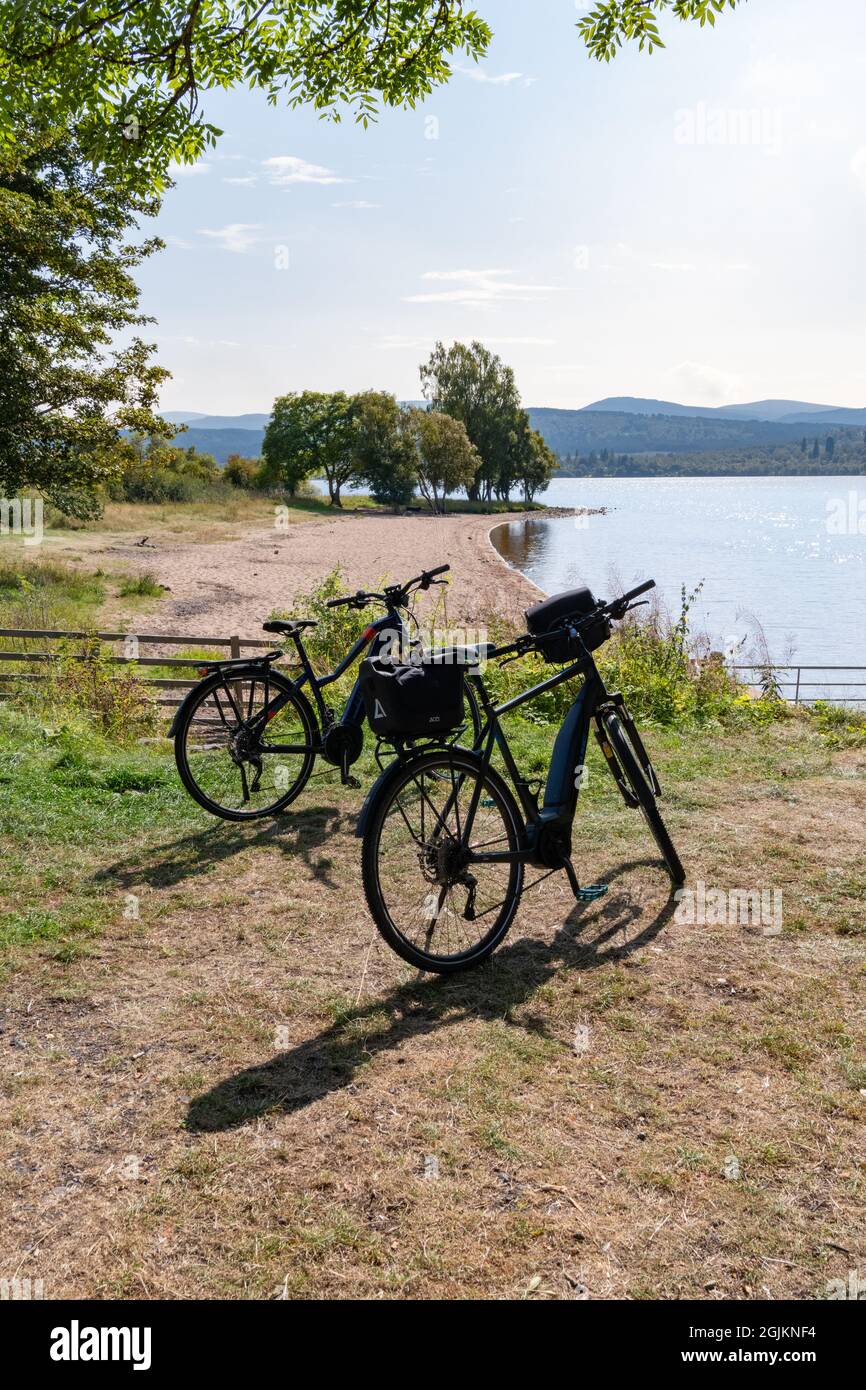 Radfahren rund um Loch Rannoch - Elektrofahrräder, die neben dem Strand, Loch Rannoch, Perth und Kinross, Schottland, Großbritannien, geparkt sind Stockfoto