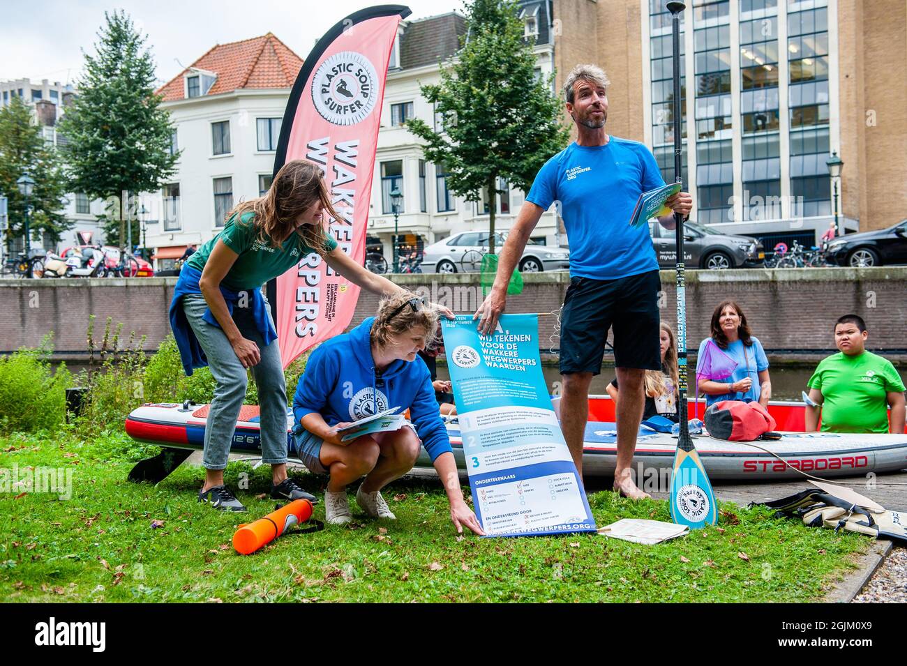 Den Haag, Niederlande. September 2021. Der zum Surfer gewordenen Biologe Merijn Tinga, besser bekannt als Plastic Soup Surfer, hält ein Plakat mit Tipps, um auf die Mülltrennung in Bildungseinrichtungen aufmerksam zu machen.der zum Surfer gewordenen Biologe Merijn Tinga, Besser bekannt als Plastic Soup Surfer baut Boards aus Plastikmüll und nutzt sie für Expeditionen, die globale Probleme rund um Plastikverschmutzung aufzeigen. Vom 1. September bis heute war er auf seinem Surfbrett aus Plastikmüll unterwegs und paddelte rund 300 km von Den Ham nach Den Haag, um auf die Trennung von W aufmerksam zu machen Stockfoto