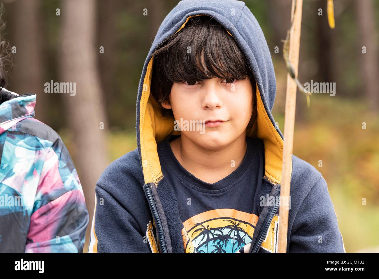 Halblanges Porträt eines weißen kaukasischen Jungen mit braunem Haar, das ein Kapuzenpullover trägt. Stockfoto