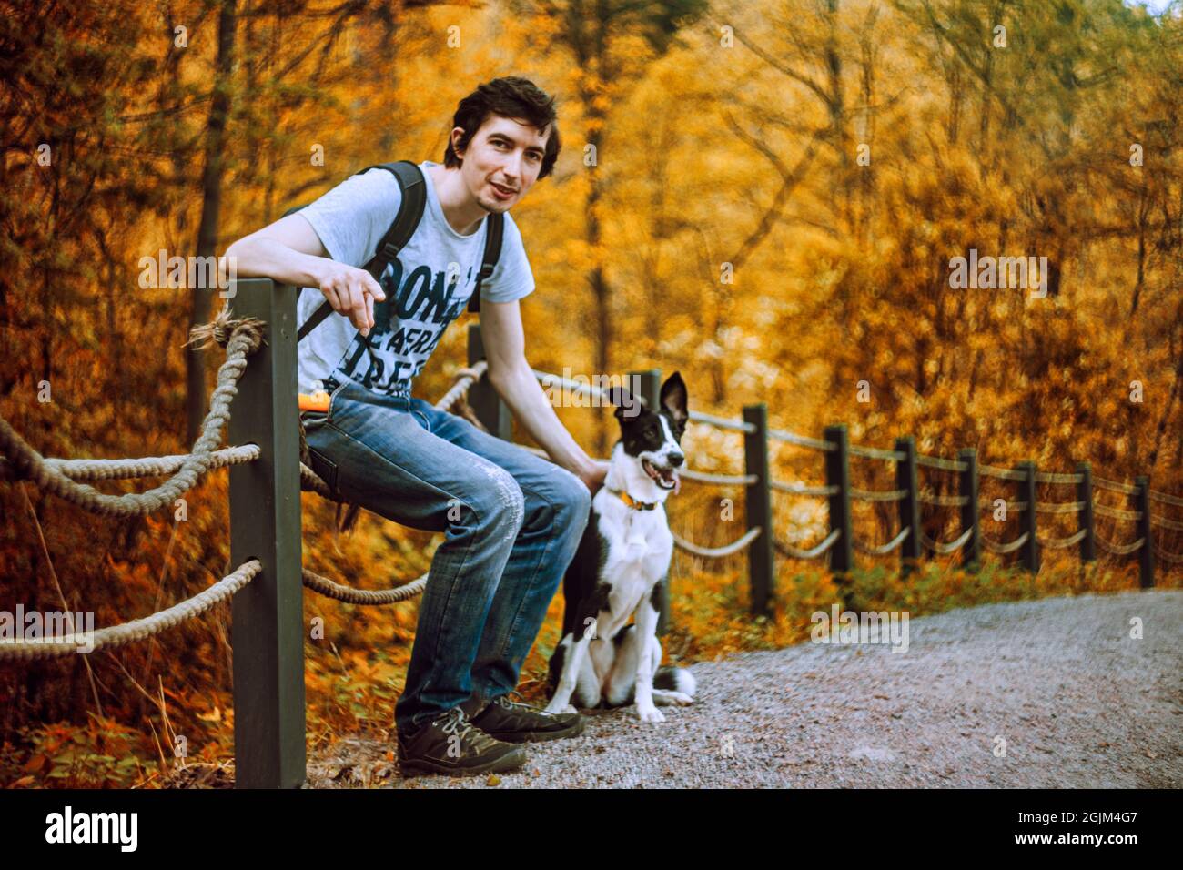 Ein hübscher erwachsener Mann posiert mit seinem Hund Stockfoto