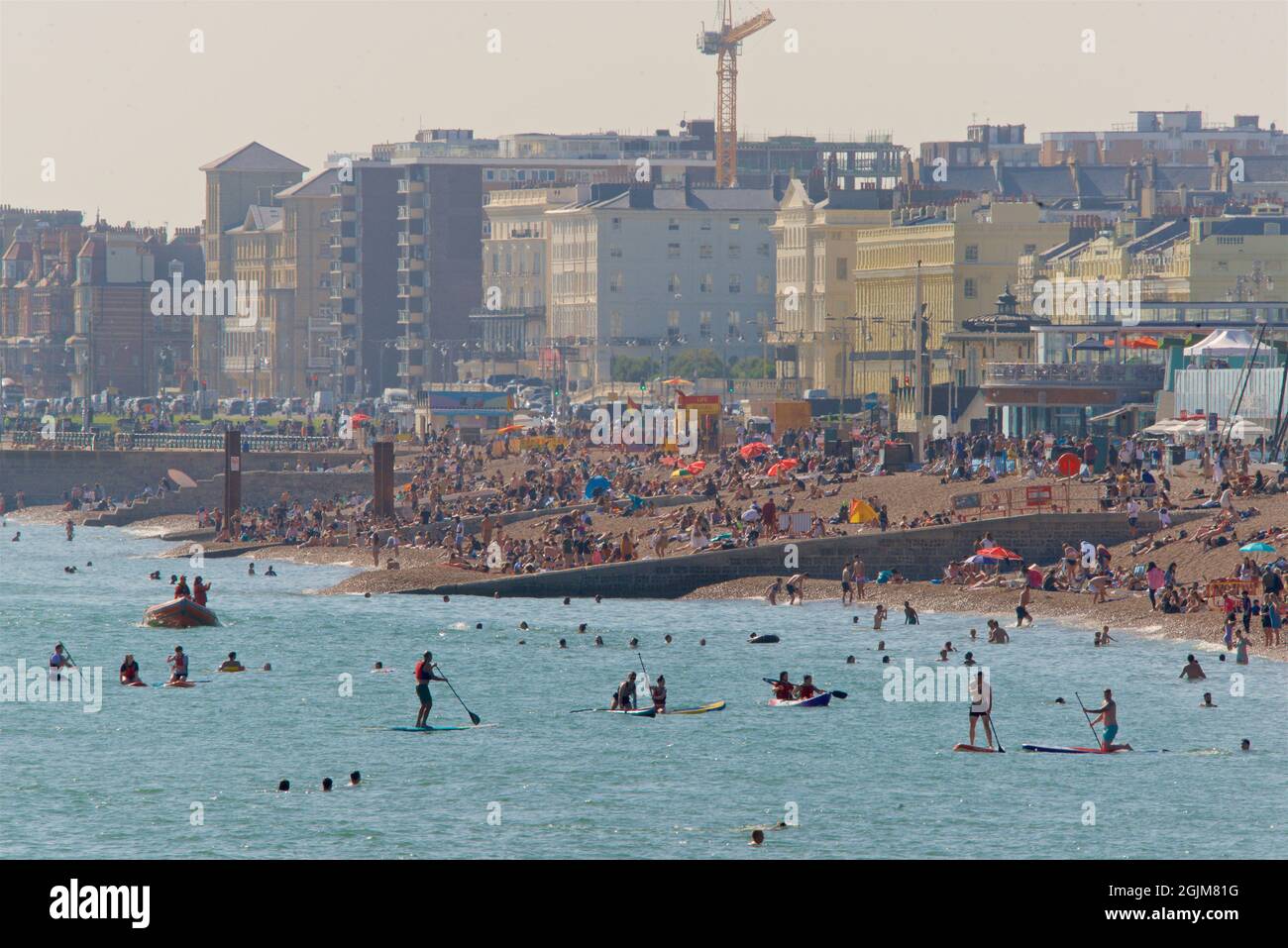 Überfüllte Strände im Zentrum von Brighton und Hove. Westlich vom Brighton's Palace Pier. Sommerferien. Sussex, England, Großbritannien. Paddlebarder Stockfoto