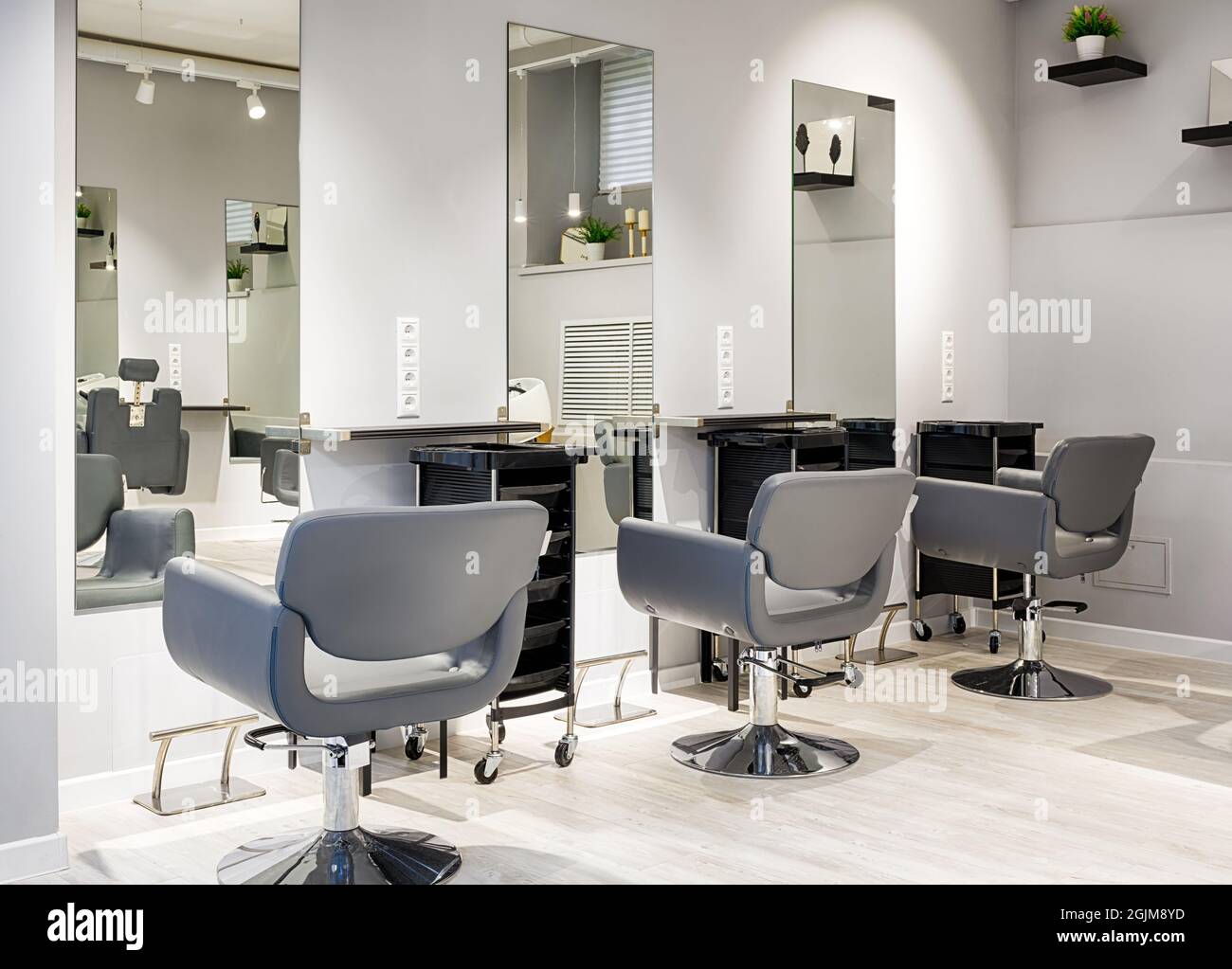Friseursalon, moderner Schönheitssalon nach Renovierung. Im leeren Friseurladen mit Spiegeln und Ledersesseln. Sauberer, trendiger Friseursalon Stockfoto