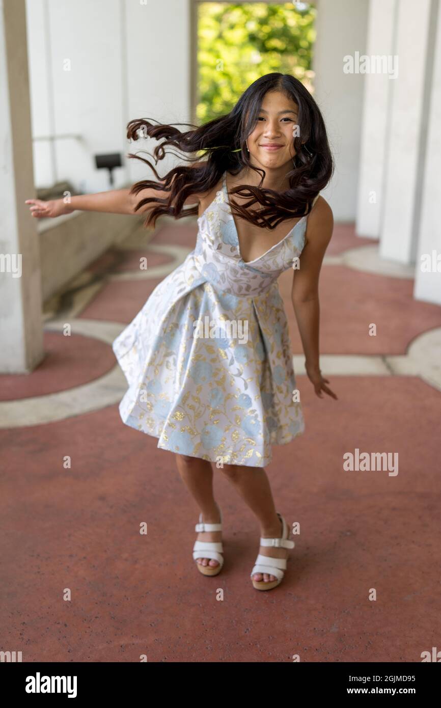 Teenage Asian Girl in Party Dress mit ihren Armen ausgestreckt wie ein Flugzeug Stockfoto