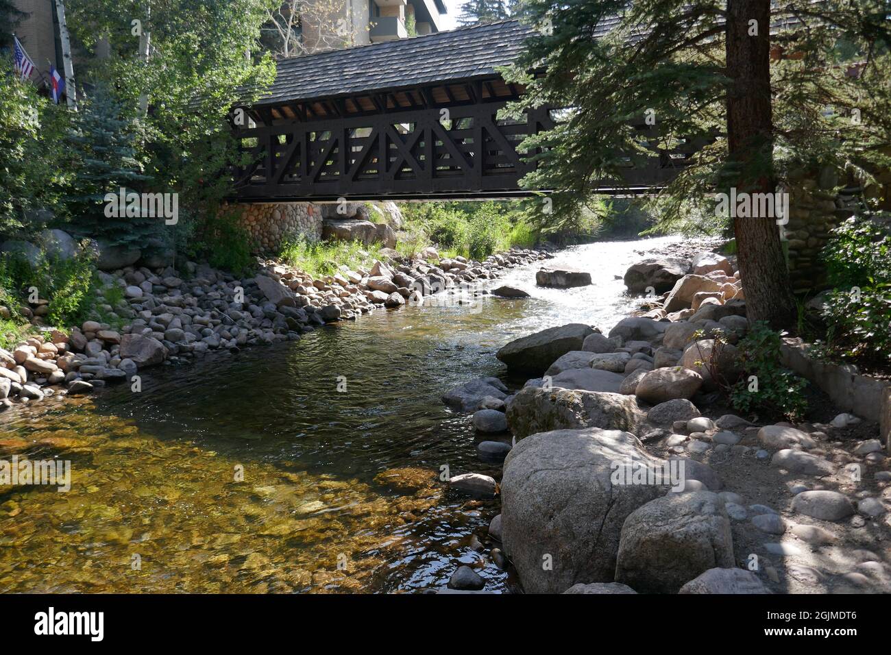 Überdachte Fußgängerbrücke über den malerischen Bergbach Stockfoto