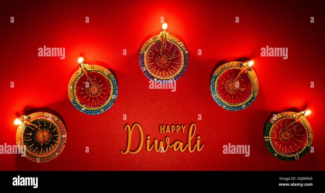 Happy Diwali - Ton Diya Lampen leuchten bei Dipavali, hinduistische Lichterfest feiern. Bunte traditionelle Öllampe diya auf rosa Hintergrund Stockfoto