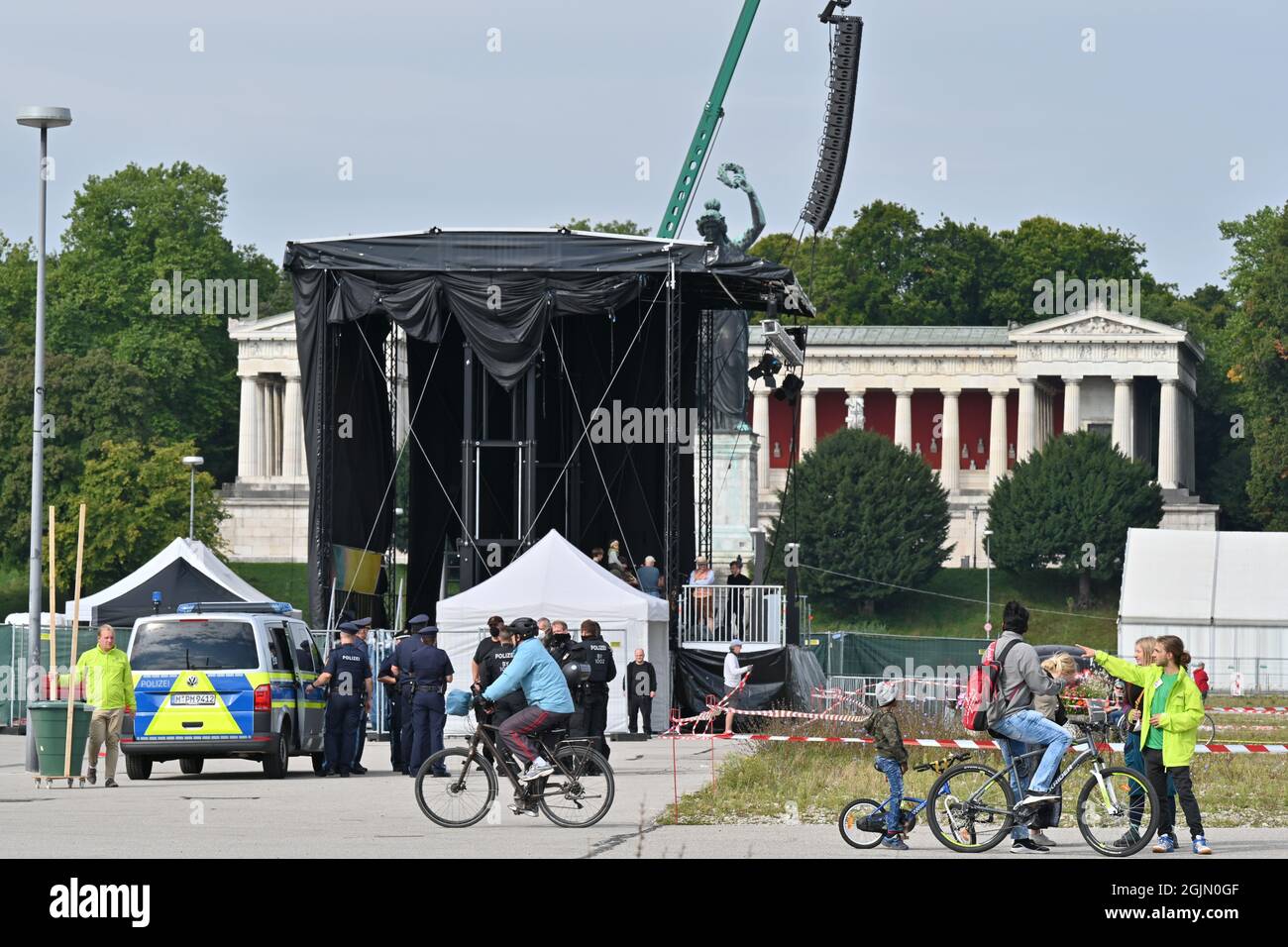 München, Deutschland. März 2020. Radfahrer fahren über die Theresienwiese, während Polizisten im Hintergrund vor der Bühne stehen. Unter dem Motto '#getout' findet eine Demonstration und eine Fahrradrallye gegen die Internationale Automobil-Ausstellung (IAA) statt. Die Polizei erwartet bis zu 35,000 Teilnehmer für die Fahrradkundgebung und bis zu 10,000 für die Demonstration. Quelle: Felix Kästle/dpa/Alamy Live News Stockfoto