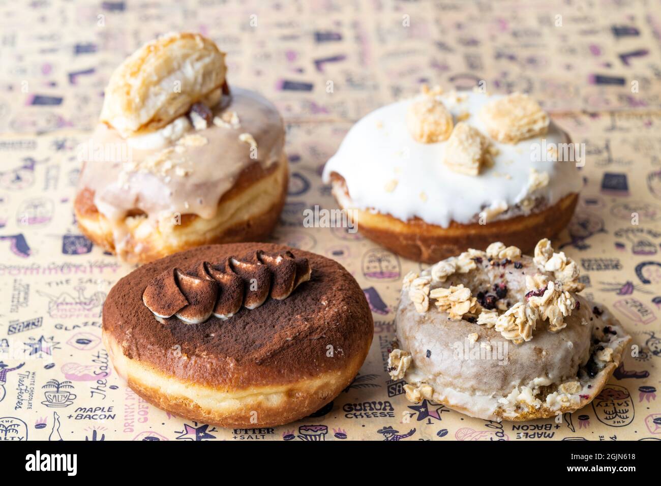 Mehrere Arten von Donuts auf Backpapier, Essen Stockfoto