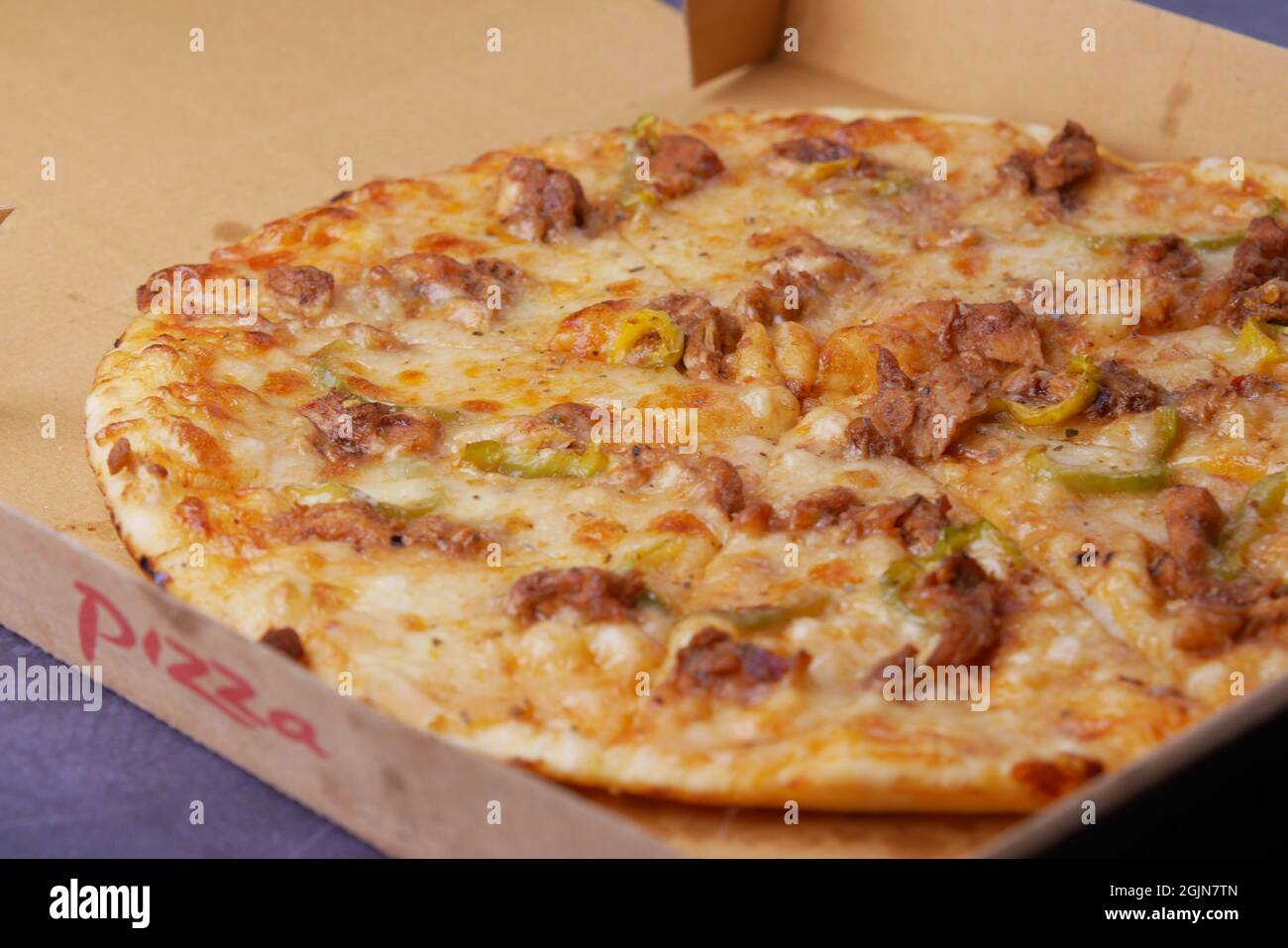 Ein Stück Käsepizza in einer Papierkiste auf dem Tisch Stockfoto