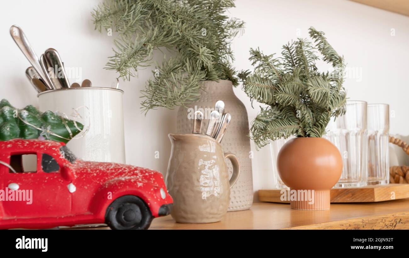 Heim Inneneinrichtung für Weihnachten. Kücheneinrichtung im Weihnachtsdekor. Rotes Auto mit einem Weihnachtsbaum im Innenraum. Küchenutensilien Stockfoto