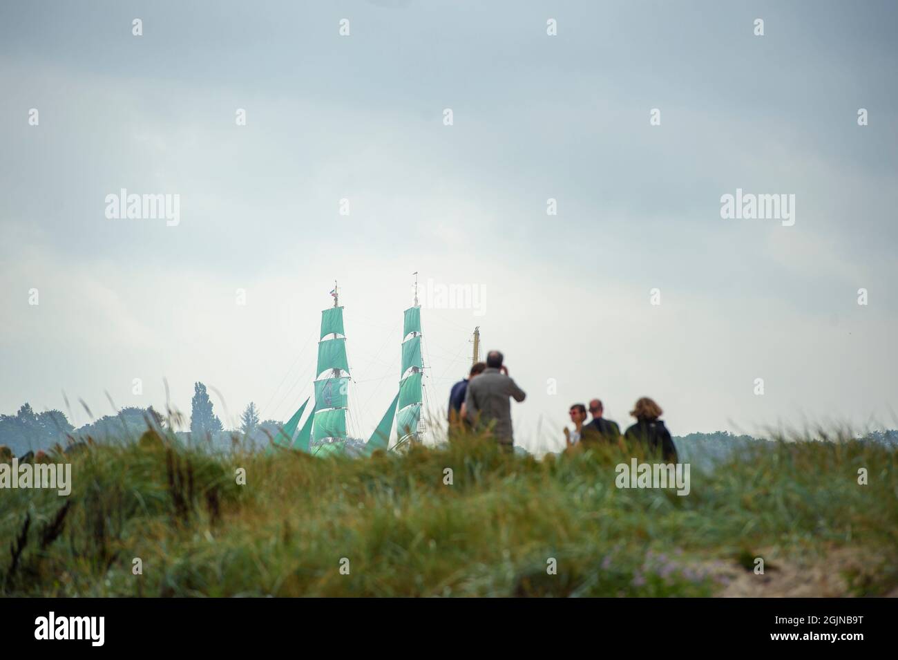 Kiel, Deutschland. September 2021. Am Strand von Friedrichsort beobachten die Menschen die Barke 'Alexander von Humboldt 2' während der traditionellen Windjammer-Parade am Ende der Kieler Woche in der Kieler Förde. Quelle: Gregor Fischer/dpa/Alamy Live News Stockfoto