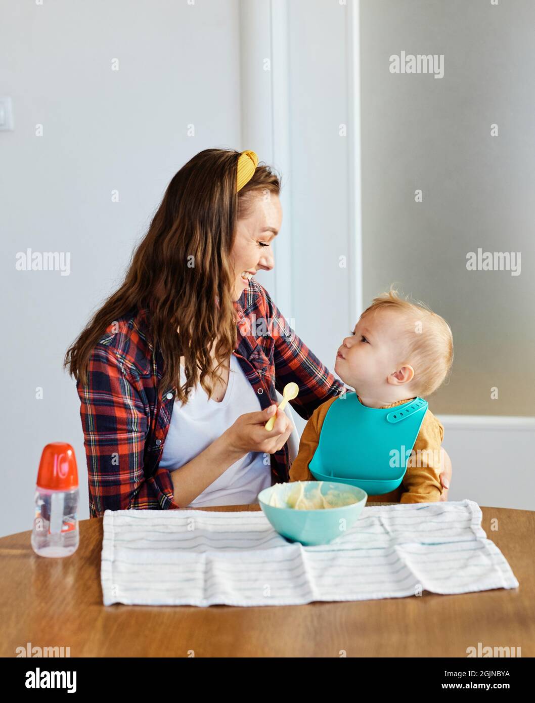 Mutter Fütterung Babynahrung Kind essen Familienpflege Kindheit niedlichen Löffel Stockfoto