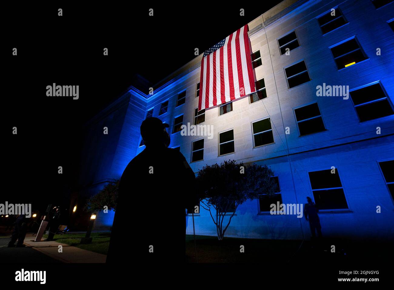 Washington DC, USA. September 2021. Washington DC, USA. 11. September 2021. Ersthelfer führen das Entrollen einer amerikanischen Flagge über die Seite des Pentagon vor Sonnenaufgang zum 20. Jahrestag der Terroranschläge von 9/11 auf das Pentagon am 11. September 2021 in Arlington, Virginia. Die Veranstaltung erinnert an die fast 3,000 Menschen, die am 11. September 2001 von Terroristen getötet wurden. Kredit: EJ Hersom/DOD/Alamy Live Nachrichten Stockfoto