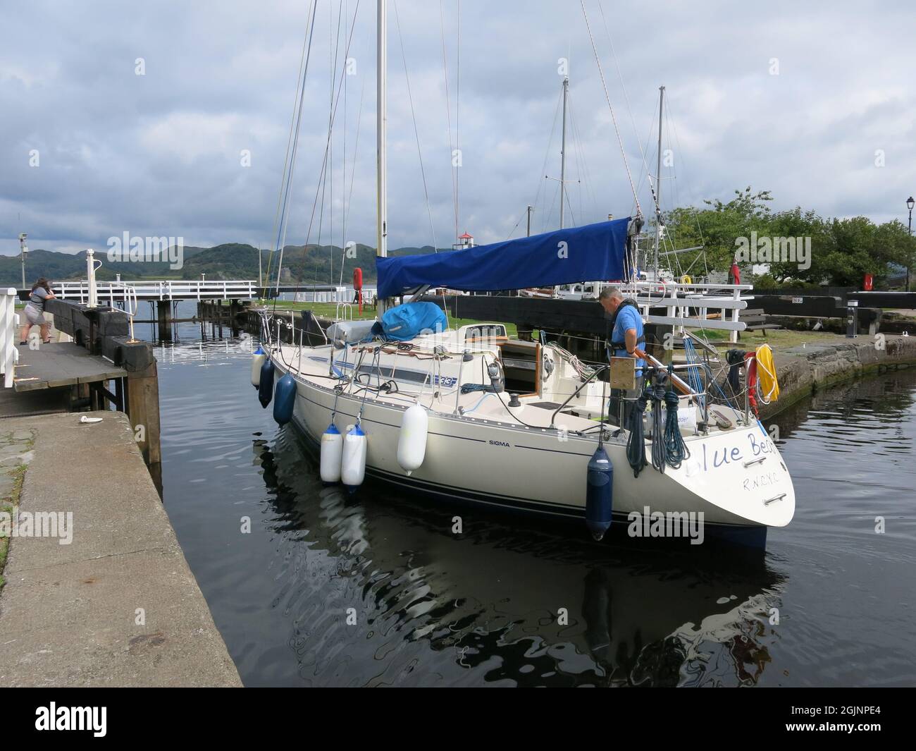 Eine Yacht hat ihre Reise entlang des Crinan-Kanals beendet und steuert auf die Schleusentore des Crinan-Beckens zu, die sich in den Sound of Jura öffnen. Stockfoto