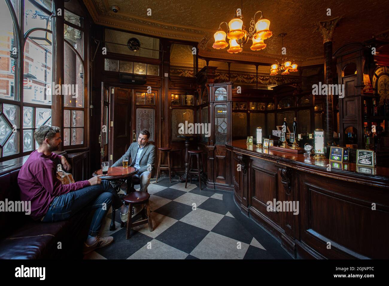 Zwei junge Männer trinken Bier im traditionellen Pub The Princess Luise in London, Großbritannien Stockfoto