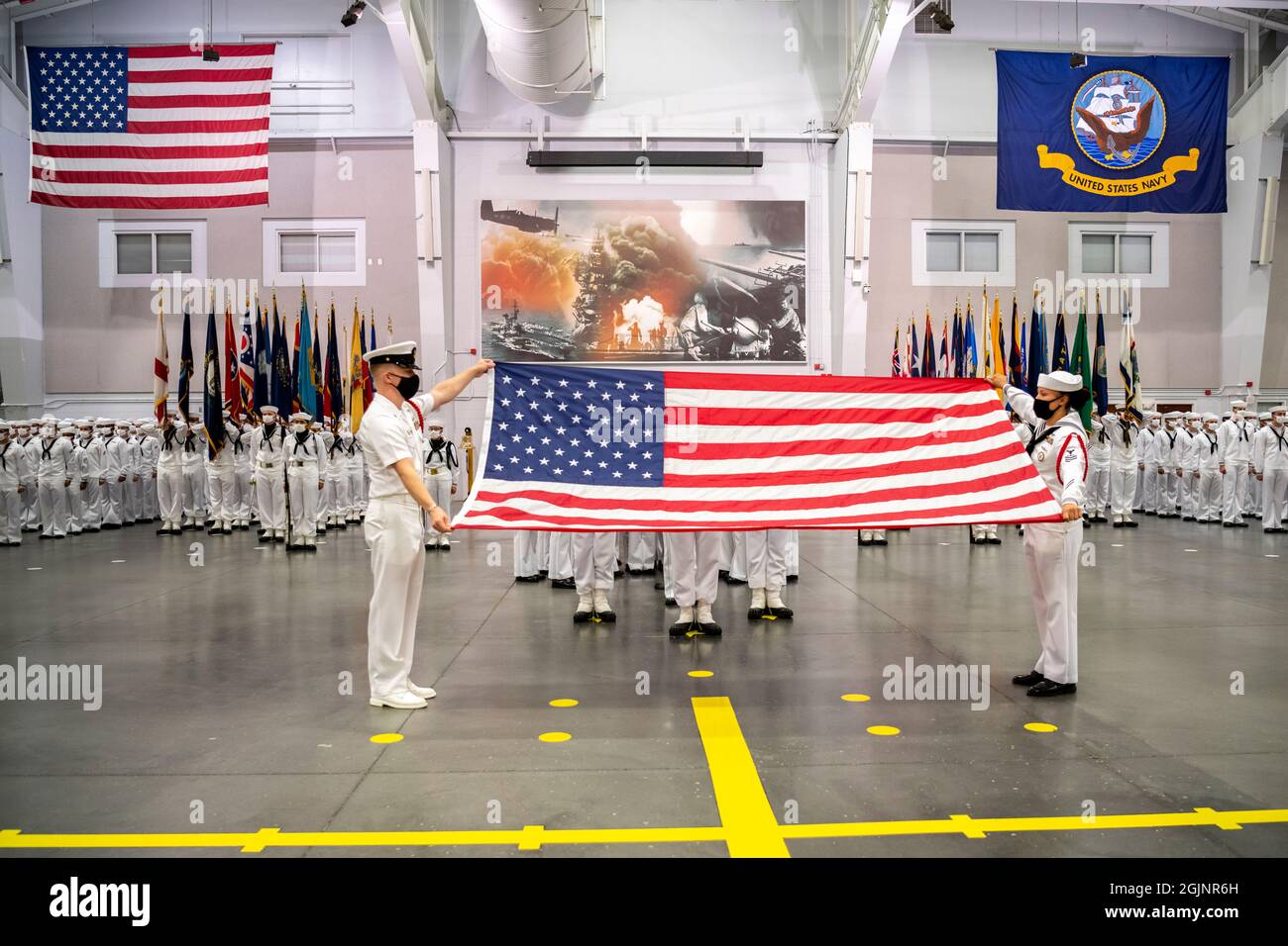 Great Lakes, Vereinigte Staaten von Amerika. 10. September 2021. Matrosen der US-Marine bereiten sich darauf vor, eine amerikanische Flagge zum Gedenken an den 20. Jahrestag der Terroranschläge von 9/11 auf das Rekrut Training Command am 10. September 2021 in Great Lakes, Illinois, zu falten. Die Veranstaltung erinnert an die fast 3,000 Menschen, die am 11. September 2001 von Terroristen getötet wurden. Kredit: MCS Brandie Nix/U.S. Navy/Alamy Live News Stockfoto