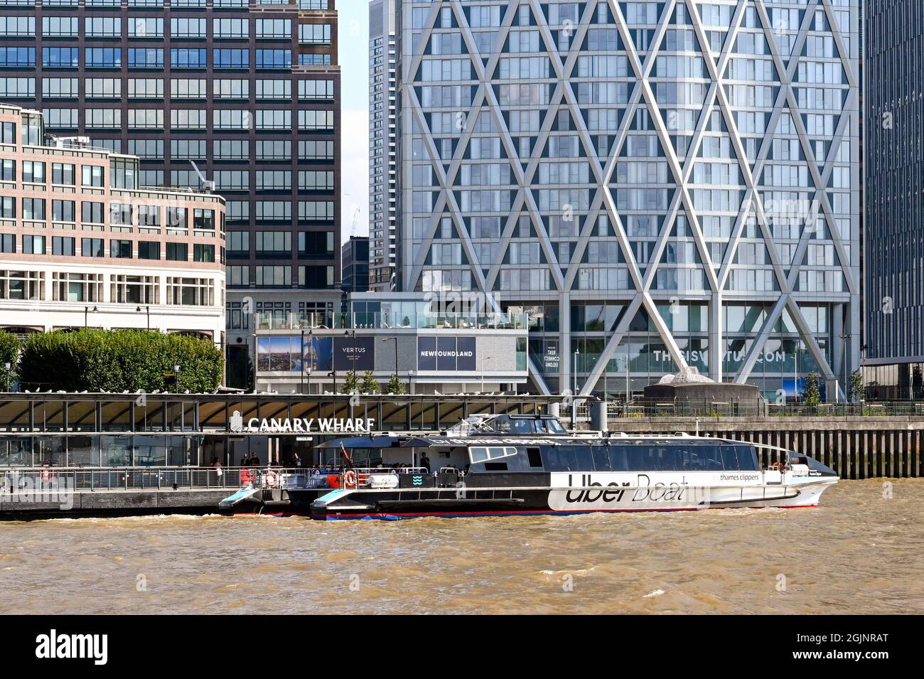 London, England - 2021. August: Das Wassertaxi der Thames Cliipers hielt vor Bürogebäuden an der Canary Wharf Stockfoto