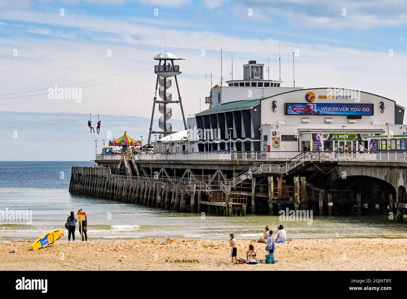 Bournemouth, Dorset, England - Juni 2021: Pier und Strand in Bournemouth. Zwei Personen sind am Seilrutsche zum Strand. Stockfoto