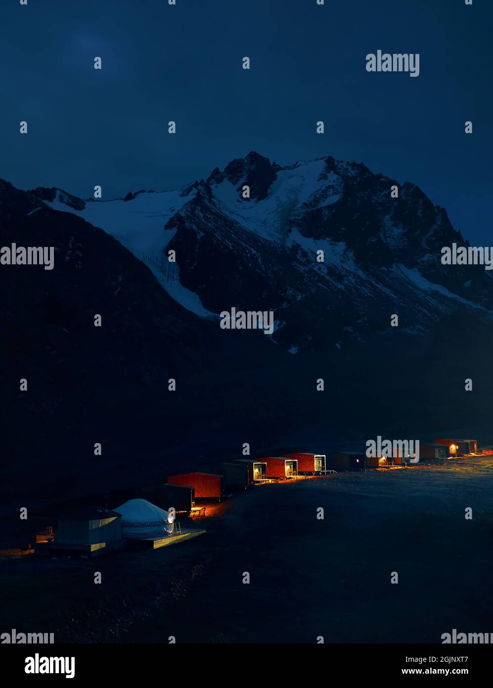 Schöne Landschaft Hotelresort mit Jurtenhaus in Shymbulak in der Nacht gegen Schneeberge in Almaty, Kasachstan. Stockfoto