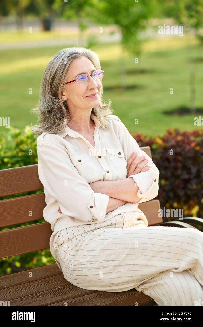 Lächelnde hübsche Frau mit gefalteten Armen auf der Brust Stockfoto
