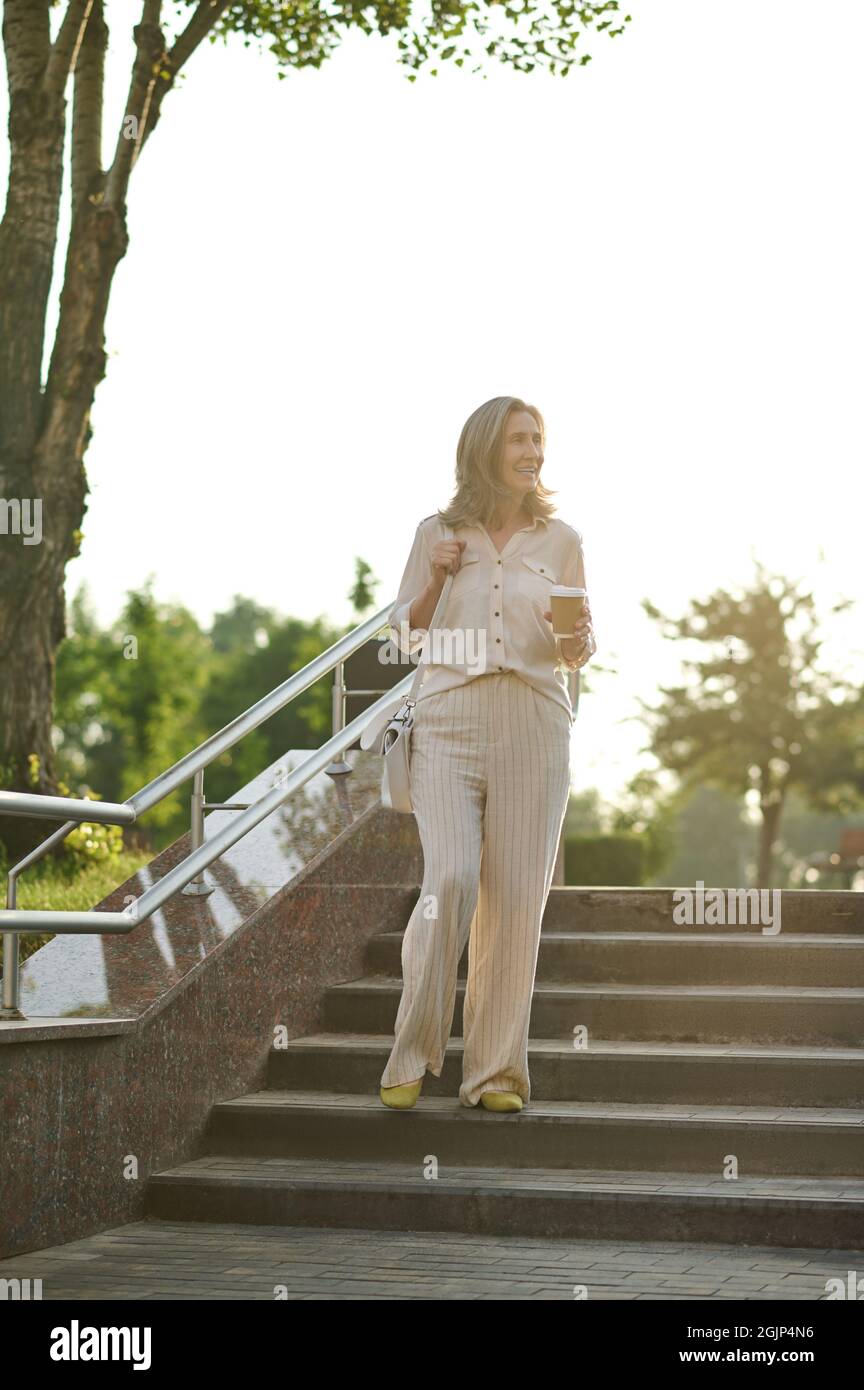 Elegante Erwachsene Frau auf der Treppe im Park Stockfoto