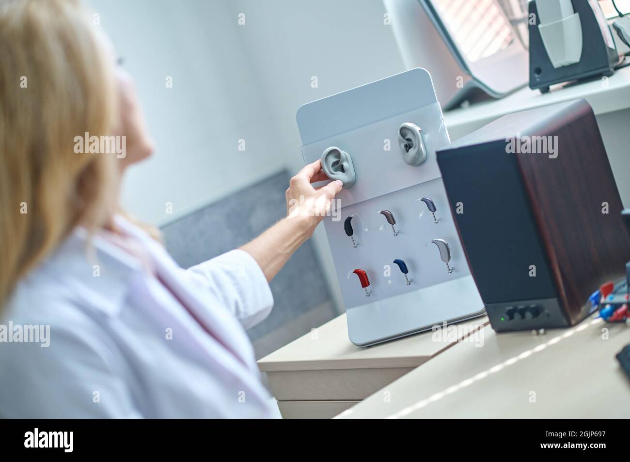 Denkender Arzt Otolaryngologe berührt künstliches Ohr Stockfoto