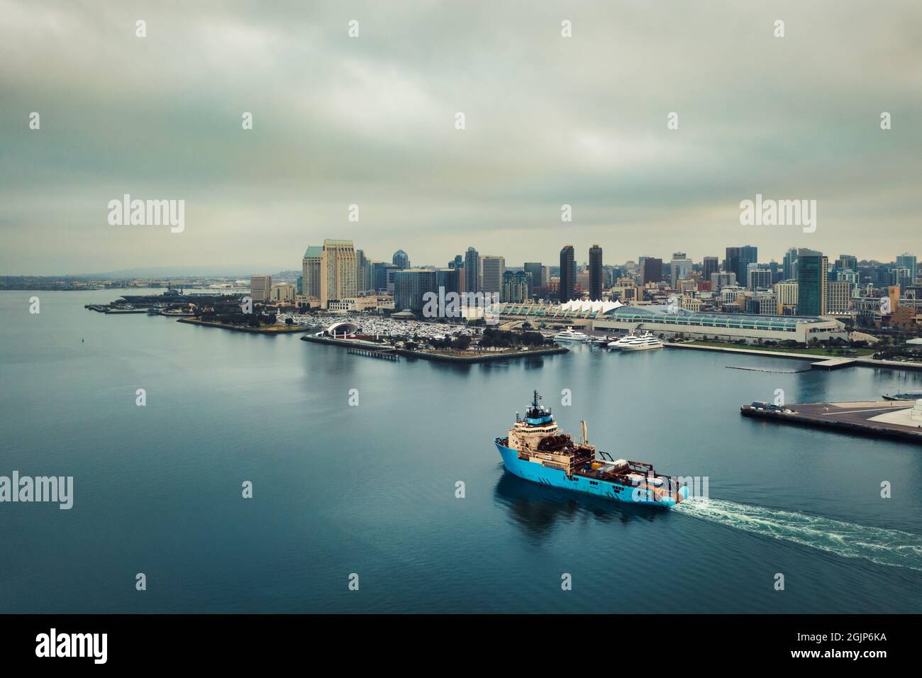 Frachter navigiert die Bucht von San Diego mit der Skyline in der Ferne. Stockfoto